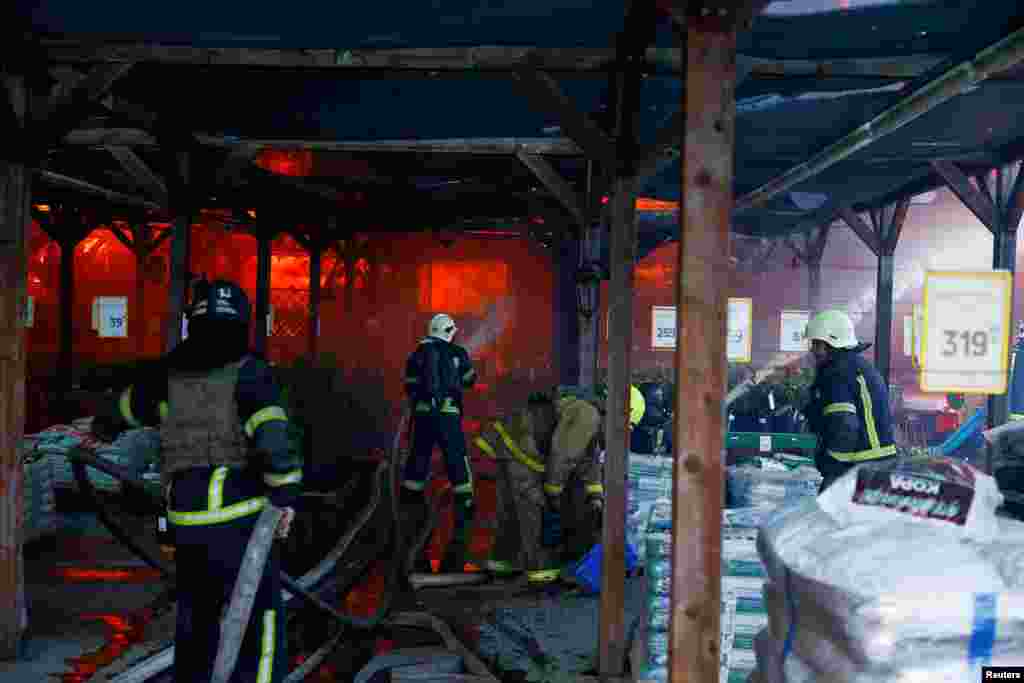 Рятувальники намагаються згасити пожежу, яка виникла внаслідок влучання авіабомб