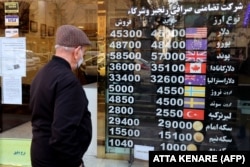 A man looks at plunging currency exchange rates at a shop in Tehran on February 21.