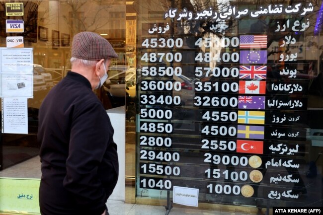 A man looks at plunging currency exchange rates at a shop in Tehran on February 21.