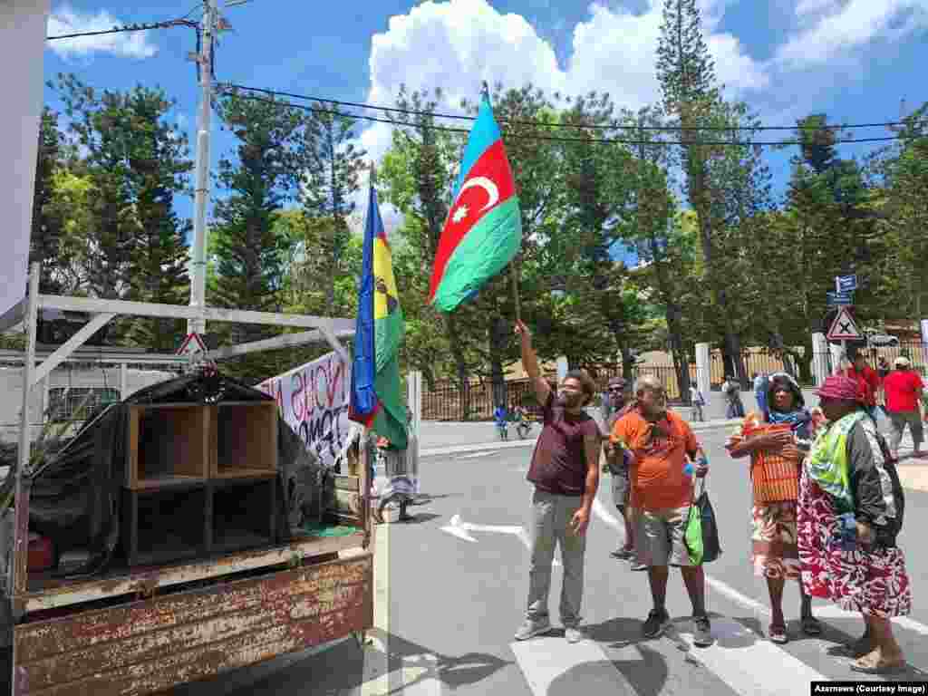 Демонстрантите во Нумеа, Нова Каледонија, веат знаме на Азербејџан. Оваа слика од јануари 2024 година е една од неколкуте на кои се прикажани знамињата и симболите на далечната кавкаска земја што ги носат домородните луѓе на Канак пред масовните немири што моментално ја разбрануваа Нова Каледонија. &nbsp;