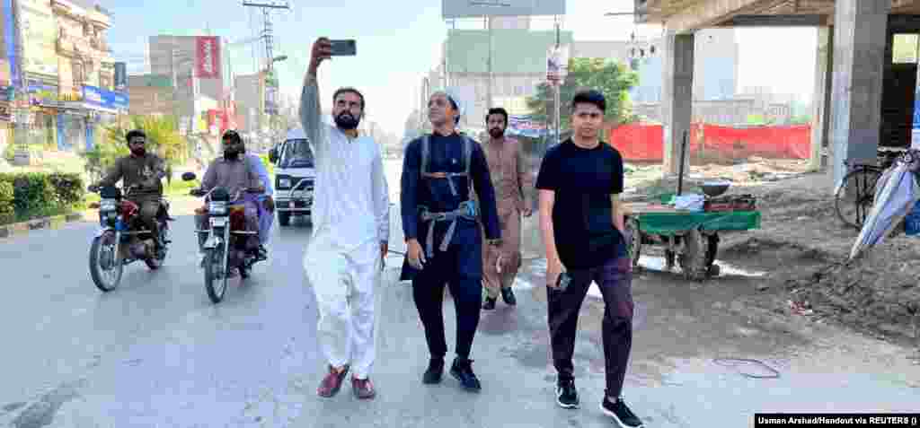 Relatives take pictures of Arshad as he sets off from his hometown of Okra, Pakistan. The hajj is one of the five pillars of Islam, and all Muslims are required to undertake it at least once in their lives if they are physically and financially able to do so. While most pilgrims travel by modern means, a smaller number choose to undertake the journey on foot.