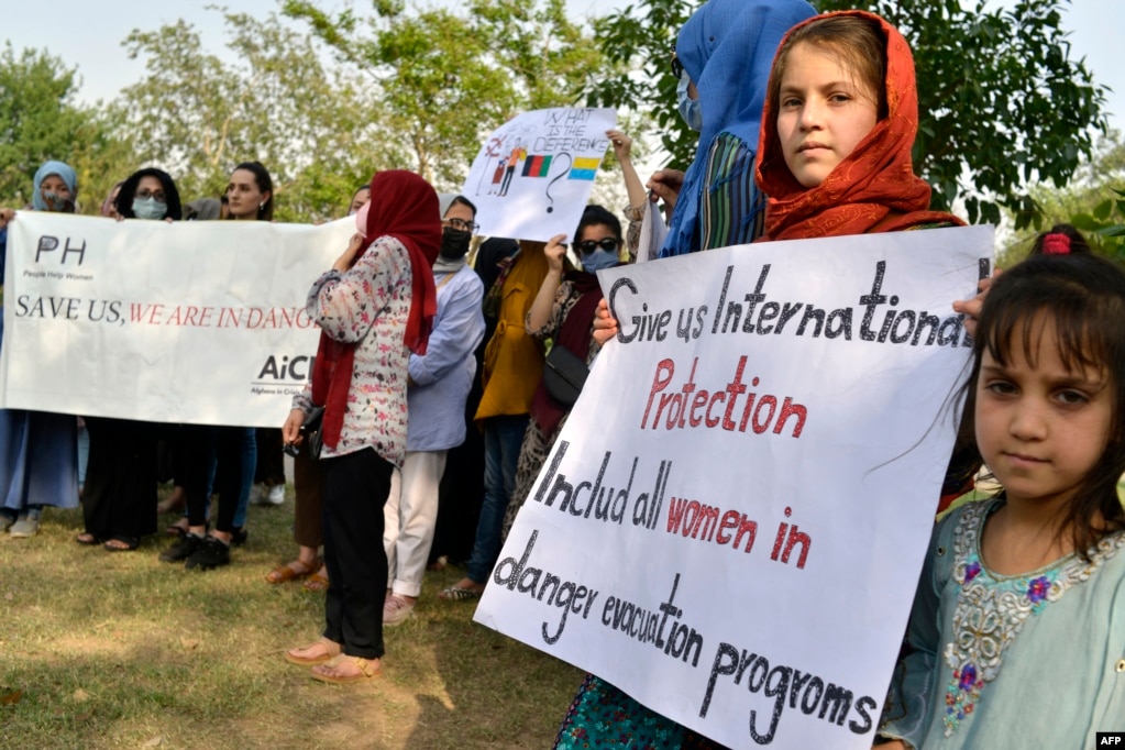 Gli afghani tengono cartelli mentre si riuniscono per chiedere aiuto alle Nazioni Unite per l'asilo all'estero a Islamabad il 12 maggio 2022.