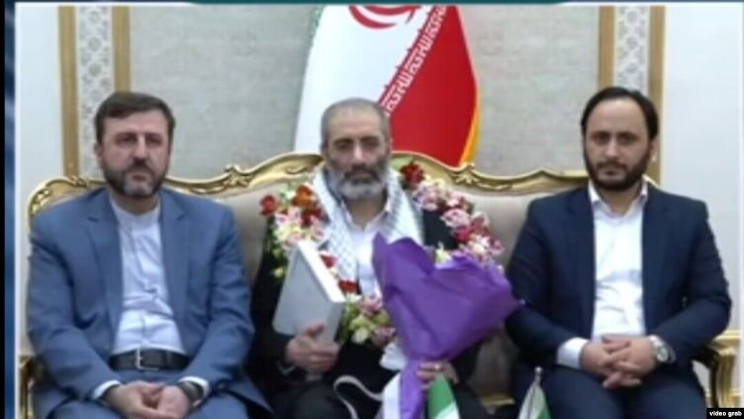 اسدالله اسدی (وسط)، محکوم به اقدام تروریستی پس از ورود به تهران در میان استقبال دو مقام جمهوری اسلامی