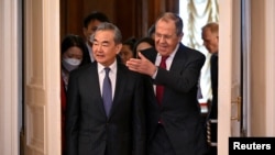 Russian Foreign Minister Sergei Lavrov (right) and China's top diplomat, Wang Yi, enter a meeting in Moscow on February 22.