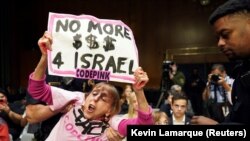 Кілька людей мали на руках написи «Звільніть Газу» та тримали плакати з вимогою «Більше жодних $$$ для Ізраїлю», а деякі вигукували «Припиніть вогонь зараз»