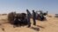 Libyan border guards talk to migrants in the desert near Libyan-Tunisian border