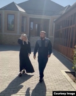 Скрин из видео: Седа Сулейманова идет по двору с чеченским уполномоченным по правам человека Мансуром Солтаевым