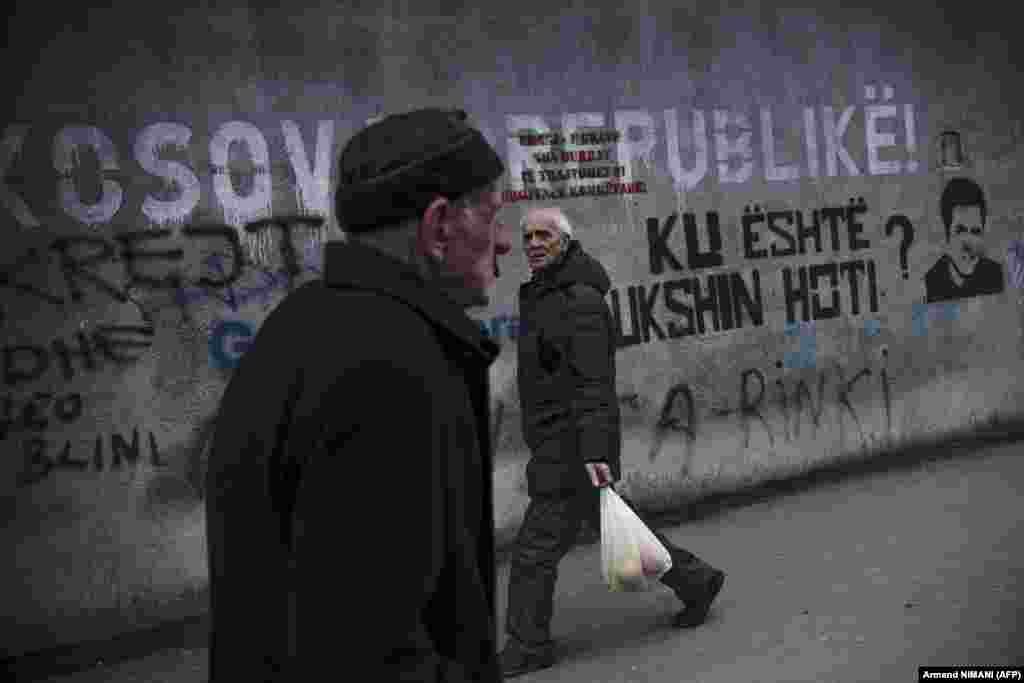 Kosovar Albanians walk past a mural reading &quot;Republic of Kosova&quot; in Pristina. Brussels hosted the leaders of Kosovo and Serbia on February 27 as the European Union turned up the pressure to reach a breakthrough deal it hopes will lead to a normalization of ties between the foes.