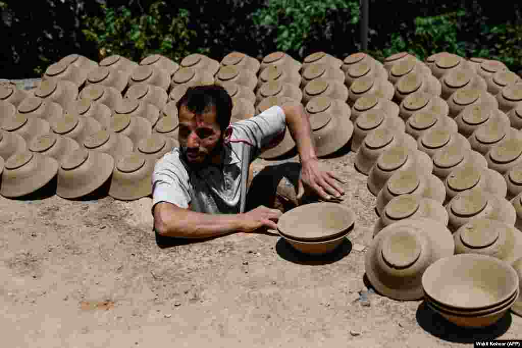 An Afghan potter makes clay bowls at a traditionally run factory in the Istalif district, in the northwest of Kabul Province.