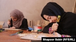 دوتن از دختران دانش آموز در حال فراگیری مهارت های حکاکی در هرات اند 