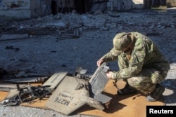 یک نظامی اوکراینی در حال وارسی یک پهپاد شاهد ۱۳۶ ساخت ایران که شاقط شده است، ۲۰۲۲