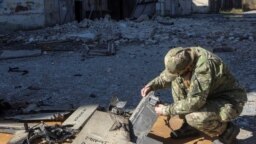 یک مأمور پلیس در حال بررسی بقایای پهپاد شاهد ۱۳۶ ساخت ایران است، خارکیف، اکتبر ۲۰۲۲