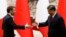Chinese President Xi Jinping (right) and French President Emmanuel Macron shake hands at the Great Hall of the People in Beijing on April 6, 2023.