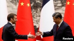 Președintele chinez Xi Jinping și președintele francez Emmanuel Macron își strâng mâna în Sala Mare a Poporului, la Beijing, China, 6 aprilie 2023. 