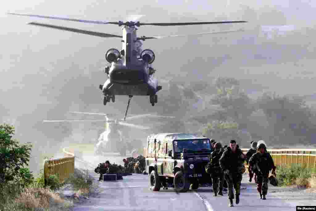 Soldați britanici coboară dintr-un elicopter pe un pod din orașul Kacanik, în sudul Kosovo, pe 12 iunie 1999. Sute de soldați NATO &ndash; inclusiv Gurkha, temuții militari nepalezi, au fost folosiți pentru a securiza podul. În prezent, casele sunt aliniate de-a lungul drumului spre pod, care a fost reconstruit.