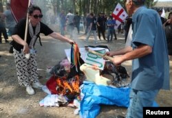 Protestatari anti-LGBTQ care au reușit să spargă cordonul de poliție fac un foc de tabără în zona destinată Tbilisi Pride Fest, în Tbilisi, Georgia, 8 iulie 2023.