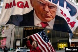 Pristalica bivšeg predsjednika SAD-a Donalda Trumpa drži američku zastavu ispred Trump Towera u New Yorku, SAD, 1. oktobra 2023.