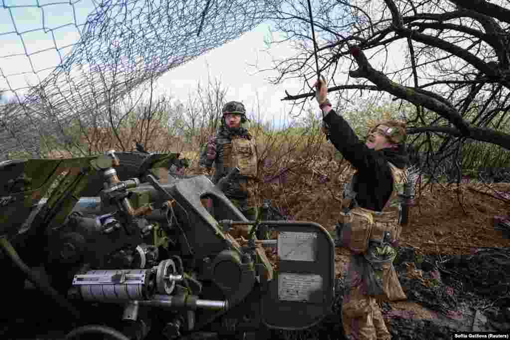 Another Ukrainian soldier checks netting that is used to protect them from Russian drones.