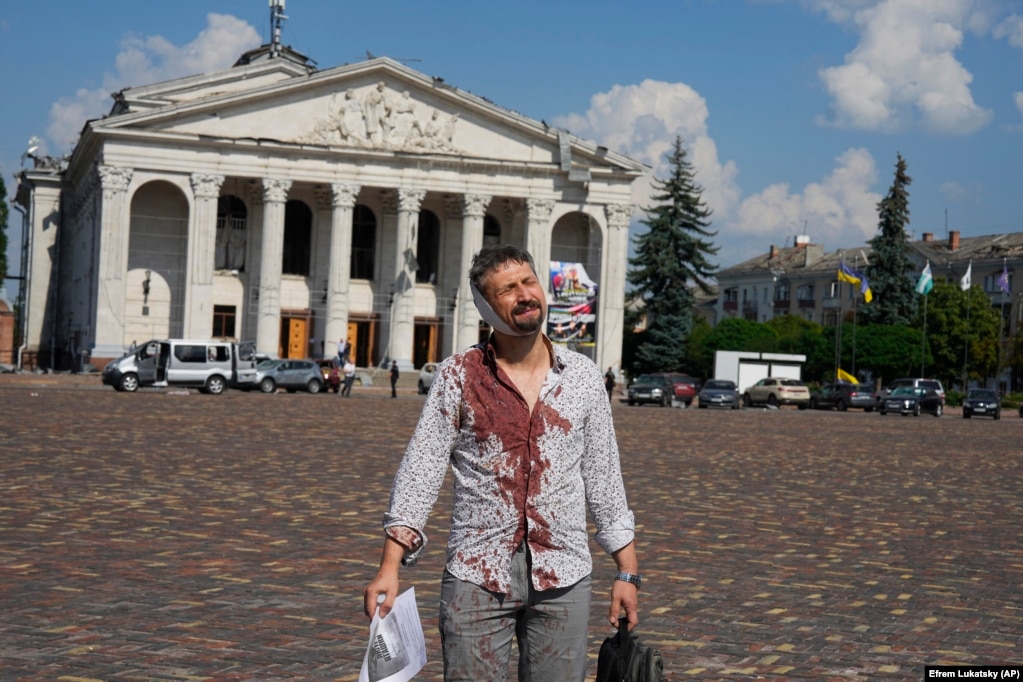 Një burrë i plagosur pas një sulmi rus shihet duke ecur në sheshin Krasna ndërsa prapa shihet Teatri Rajonal Akademik i Muzikës dhe Dramës, Taras Shevchenko, në Chernihiv, Ukrainë, 19 gusht 2023.