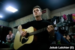 Oleksiy Savkevych plays guitar in a cellar in Avdiyivka in April 2022.