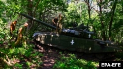 Украинские военные готовятся к ведению огня по позициям армии РФ из трофейного танка Т-80, захваченного во время осенней наступательной кампании. Недалеко от Бахмута в Донецкой области, 19 июня 2023 года
