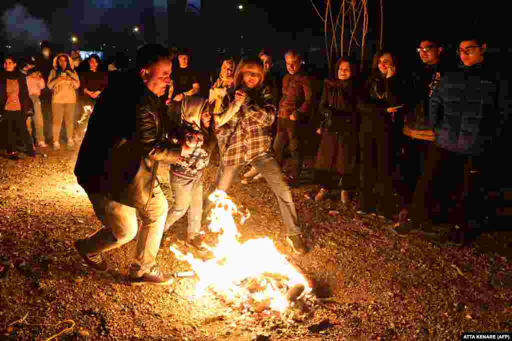 An Iranian couple helps a child jump over a fire as part of the ritual, which dates back to Zoroastrian times. The official turnout of 41 percent was the lowest for legislative elections since the 1979 Islamic Revolution. Critics claim the real turnout was likely even lower. &nbsp;
