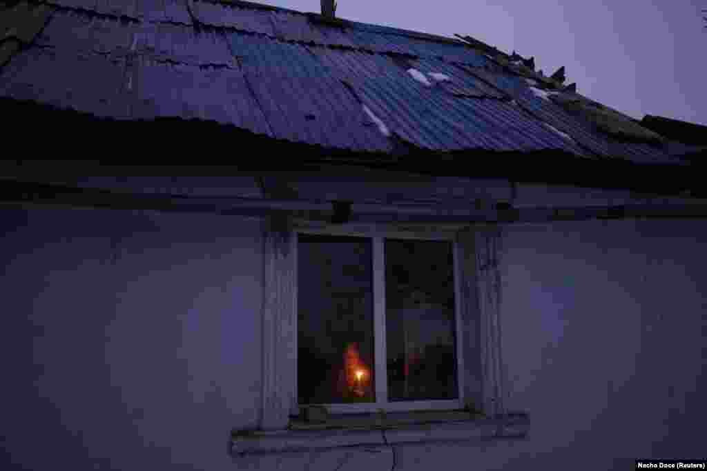 Tetyana looks out the window of the only room of her house that still has a roof.&nbsp; Though the brothers occasionally enjoy an odd glass of horilka, a Ukrainian spirit, the couples keep largely to themselves. &nbsp;