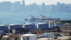 A Chinese vessel is seen near oil tanks at the China National Petroleum Corporation's petrochemical facility in Dalian, China.