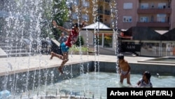 Një grup fëmijësh në Prishtinë freskohen në një shatërvan ndërsa një valë rekord e të nxehtit përfshiu kryeqytetin e Kosovës në korrik. (Arben Hoti, Byroja në Prishtinë e REL-it)