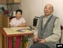 A former Korean forced laborer in Sakhalin sits with his wife at their new apartment in Ansan, southwest of Seoul, in February 2000, shortly after returning to his homeland as part of a resettlement program agreed to by South Korea, Japan, and Russia.