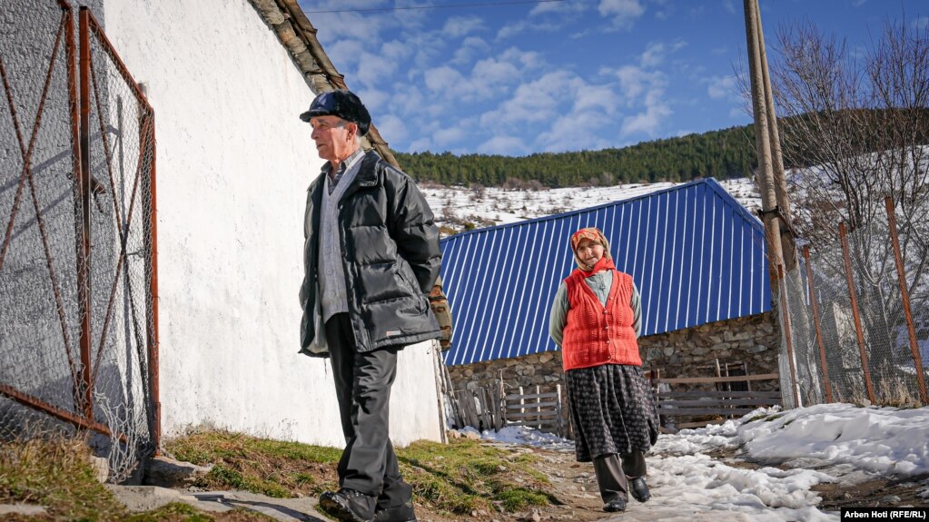 Një burrë dhe grua në moshë teksa ecin rrugëve të fshatit Borje.
