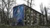 Мурал із зображенням жінки з дитиною на стіні сильно пошкодженого внаслідок обстрілів армією РФ житлового будинку в Авдіївці на Донеччині, 4 квітня 2023 року
