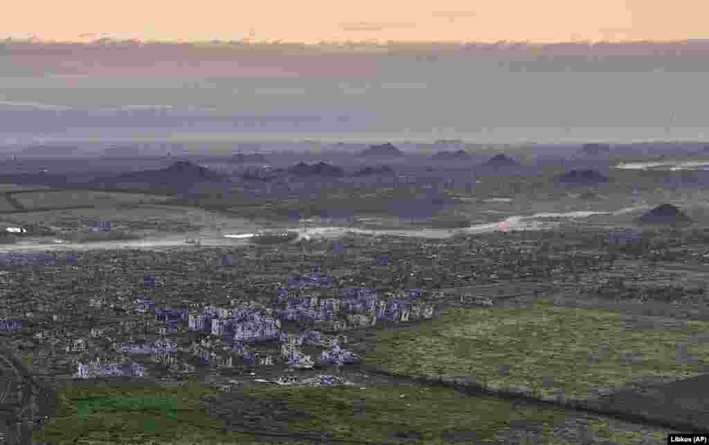 The ruins of Maryinka with towering slag heaps from local coal mines in the background