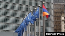 Belgium - EU and Armenian flags fly outside the EU headquarters in Brussels.