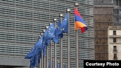 Belgium - European Union and Armenian flags fly outside the EU headquarters in Brussels.