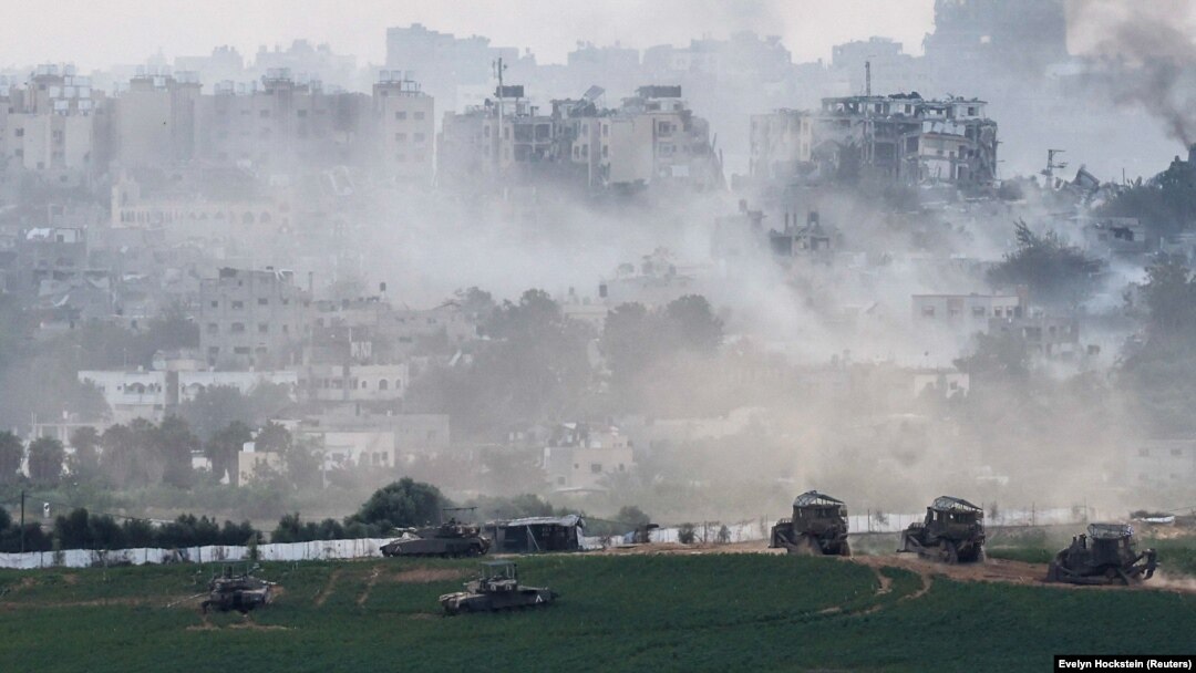 Tancuri israeliene și alte vehicule militare în interiorul Fâșiei Gaza, văzute din Israel, pe 29 octombrie 2023.