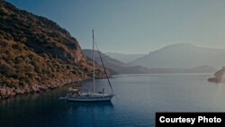 The Oikumena at anchor in a bay in the Mediterranean.