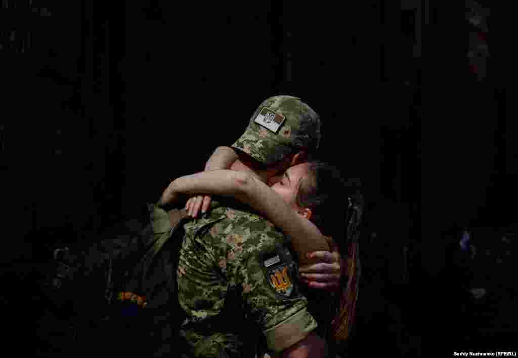 A Ukrainian soldier says goodbye to his partner after a short break from frontline duty at the train station in Kramatorsk.