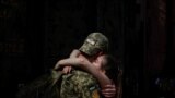 A Ukrainian soldier says goodbye to his partner after a short break from frontline duty at the train station in Kramatorsk.