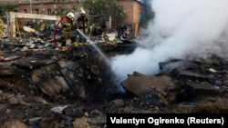 Пожежники гасять пожежу, що виникла на місті падіння уламків російської ракети. Київ, 21 вересня 2023 року