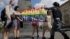 Participanții țin un steag curcubeu în timp ce un polițist îi oprește în timpul unui miting al comunității LGBT în centrul Moscovei, Rusia, 30 mai 2015. 