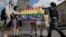 Participanții țin un steag curcubeu în timp ce un polițist îi oprește în timpul unui miting al comunității LGBT în centrul Moscovei, Rusia, 30 mai 2015. 