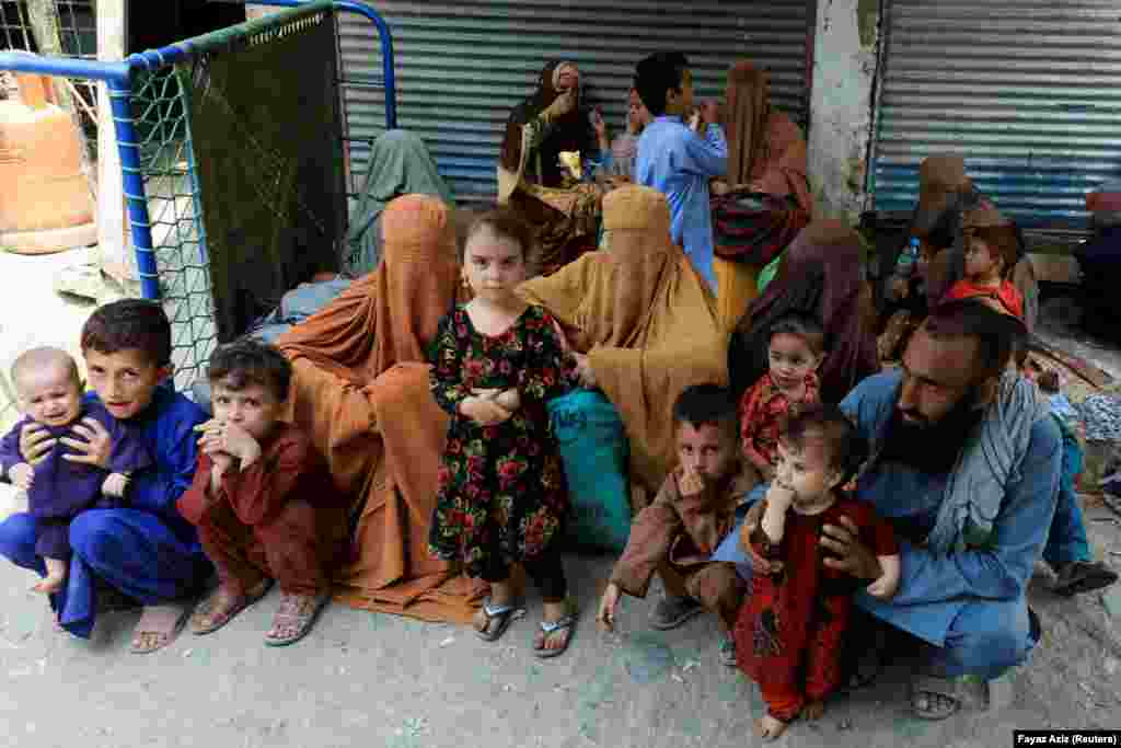 Muhammad Ismail, 40, sits with his family while they wait to cross the main Afghanistan-Pakistan border crossing, in Torkham, Pakistan.