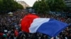 Протестувальник тримає французький прапор, коли люди збираються на Площі Республіки у Парижі, Франція, 7 липня 2024 року. 