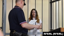 Aleksandra Skochilenko appears in the defendant's cage during her trial in St. Petersburg.