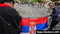 Dy gra duke vendosur flamurin serb në një ndalesë gjembore para ndërtesës komunale në Zveçan. Fotografi ilustruese nga arkivi.