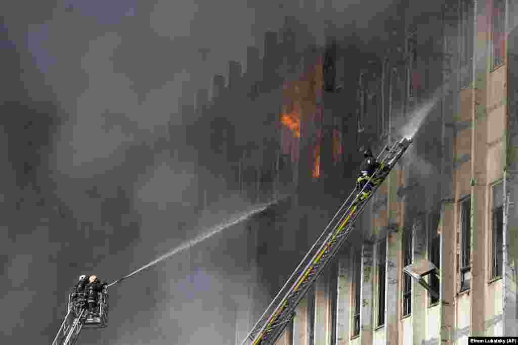Firemen work to extinguish the fire in the industrial building. &nbsp;