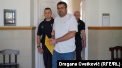 Ukrainian citizen Andriy Naumov (center) arrives for a court hearing in Nis in September 2023. 