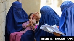 Afghan health workers administer polio vaccination drops to a child during an inoculation campaign in Jalalabad. (file photo)