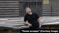 Андрей Зорин возле здания старинной пожарной каланчи в деревне Березник. Последний год он помогает проводить противоаварийные работы на этом памятнике архитектуры. Фото: Юлия Невская